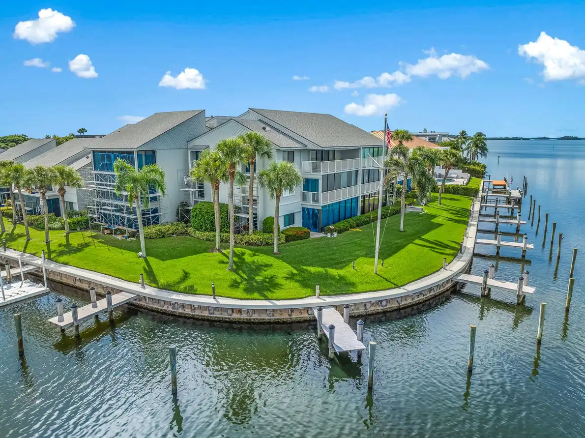 1776 Mooringline Drive, PH-C: the residence seen from the water, with its private dock, lawn and point-lot frontage