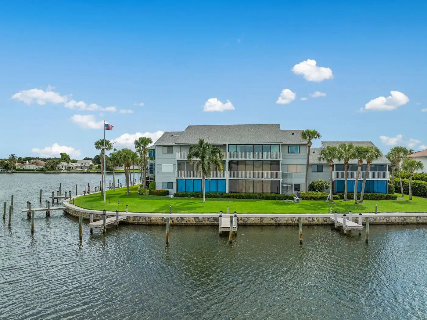 1776 Mooringline Drive, PH-C: the building and dock from across the water, showing the full waterfront exposure
