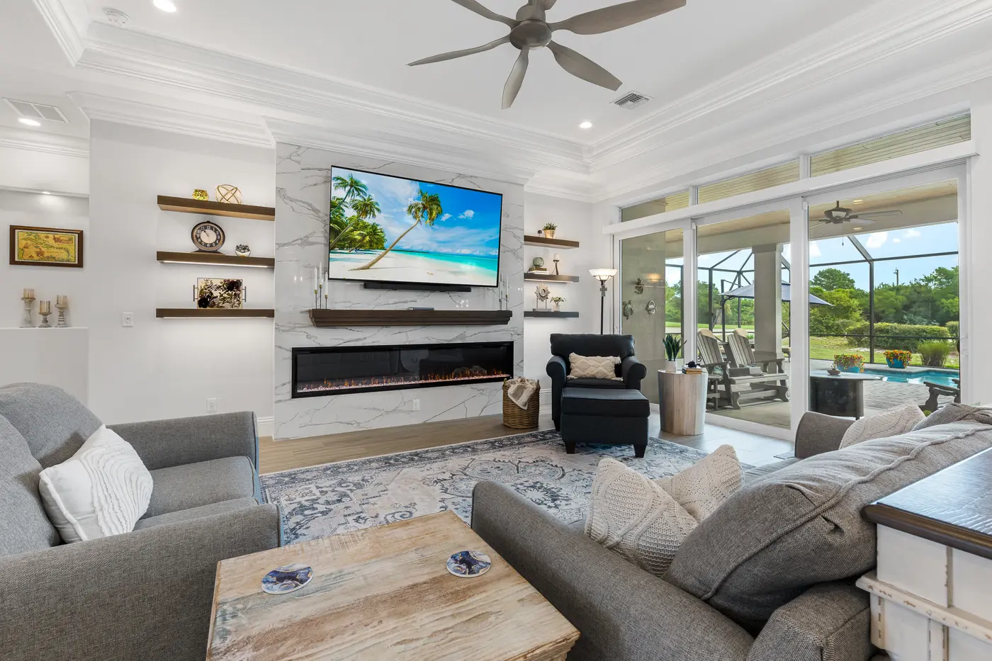 2340 Pine Valley Road: the great room, with the quartz fireplace wall and the lanai beyond